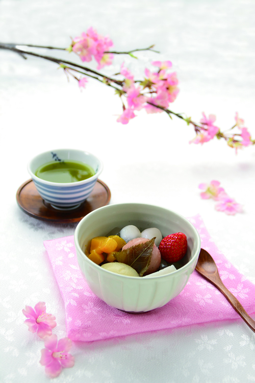お花見あんみつ \561 【タワーヤード 2 階 船橋屋】 販売期間:3 月 4 日(水)~4 月 5 日(日) 風味豊かな桜餡にもちもちの白玉や黄桃・白桃・ 苺などの彩り豊かなフルーツを添えた季節限定の あんみつで