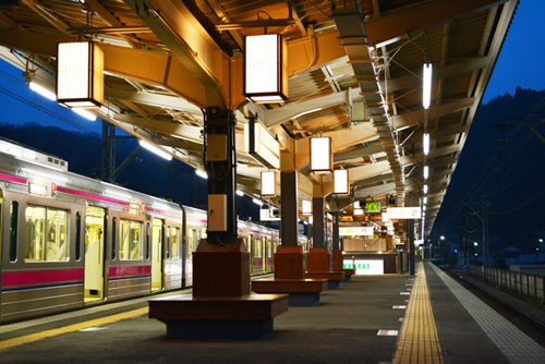 「駅のホーム」 行灯風の照明がホームを優しく照らし、案内板に天狗を入れるなど、高尾山口駅ならではの演出をしている